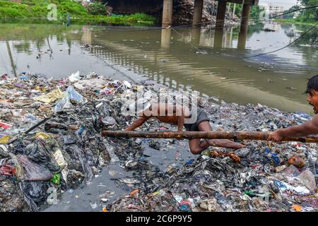 Dhaka, Dhaka, Bangladesh. 11 Luglio 2020. Lavoratori volontari ripulire le rive del fiume che circondano il canale, era un canale prima ma il deposito continuo di rifiuti urbani lo rende una terra a Savar vicino Dhaka, Bangladesh il 11 luglio 2020. Credit: Zabed Hasnain Chowdhury/ZUMA Wire/Alamy Live News Foto Stock