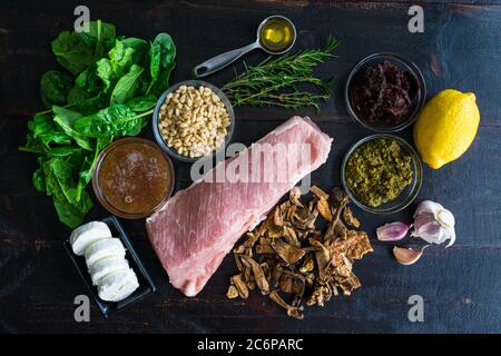 Tenderloin di maiale farcito mediterraneo ingredienti: Ingredienti crudi utilizzati per preparare un arrosto di maiale farcito Foto Stock