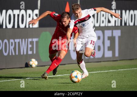 Ingolstadt, Germania. 11 Luglio 2020. Calcio: 2° Bundesliga - Releigation, FC Ingolstadt 04 - 1° FC Nürnberg, Releigation, ritorno partita all'Audi Sportpark. Michael Heinloth di Ingolstadt (l) e Fabian Nürnberger di Norimberga in un duello per la palla. Credito: Matthias Balk/dpa - NOTA IMPORTANTE: In conformità con le norme del DFL Deutsche Fußball Liga e del DFB Deutscher Fußball-Bund, è vietato sfruttare o sfruttare nello stadio e/o nel gioco le fotografie scattate sotto forma di sequenze di immagini e/o serie di foto di tipo video./dpa/Alamy Live News Foto Stock