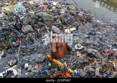 Dhaka, Bangladesh. 11 Luglio 2020. Un volontario pulisce la riva del fiume che circonda il canale. Era un canale prima ma deposito continuo di rifiuti urbani lo rende una terra a Savar. Credit: SOPA Images Limited/Alamy Live News Foto Stock