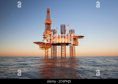 Installazione offshore in mezzo al mare al tramonto Foto Stock