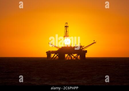 Installazione offshore in mezzo al mare al tramonto Foto Stock