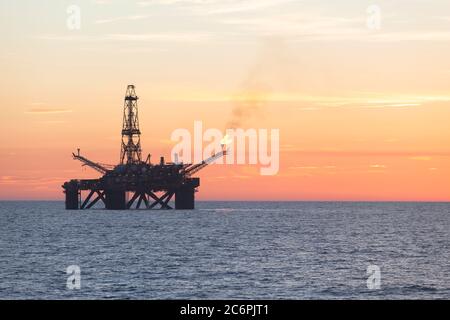 Installazione offshore in mezzo al mare al tramonto Foto Stock