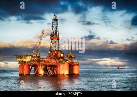 Installazione offshore in mezzo al mare al tramonto Foto Stock