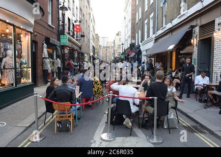 Persone che socializzano a Soho, nel centro di Londra, dopo l'abolizione di ulteriori restrizioni di blocco del coronavirus in Inghilterra. I rivelatori sono esortati a ricordare l'importanza della distanza sociale, come i pub si stanno addentando per il secondo fine settimana del commercio dopo l'abolizione delle misure di blocco. Foto Stock