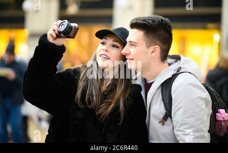 Coppia giovane di turisti fotografare in città Foto Stock