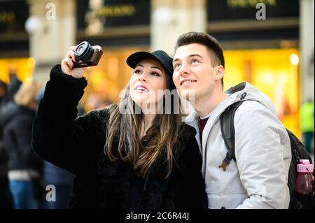 Coppia giovane di turisti fotografare in città Foto Stock