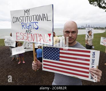 Cleveland, Stati Uniti. 11 Luglio 2020. Un uomo ha i segni durante una protesta contro l'ordine di copertura del viso dell'Ohio sulla scia del Coronavirus (COVID-19) all'Edgewater Park a Cleveland, Ohio, sabato 11 luglio 2020. Foto di Aaron Josefczyk/UPI Credit: UPI/Alamy Live News Foto Stock