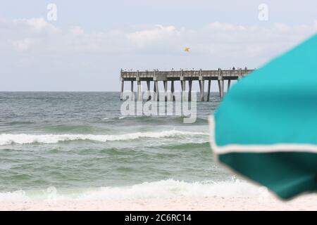 Potente surf in spiaggia a Pensacola Florida con molo in background. Foto Stock
