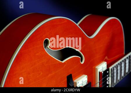 Dettaglio di una chitarra elettrica a corpo chiuso Ibanez AF75 in arancione trasparente con foro f e rilegatura. Foto Stock