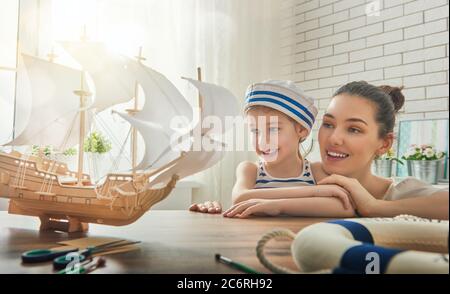 Madre e suo bambino che fa la nave di modello. Sogni di mare, avventure e viaggi. Foto Stock