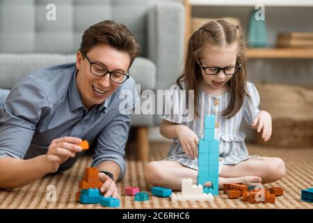 Buon giorno! Papà e sua figlia bambina stanno giocando e sorridendo. Vacanza in famiglia e insieme. Foto Stock