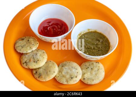 Idli (ricetta indiana del sud) con salsa di peperoncino caldo e chutney verde. Foto Stock