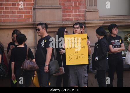 I manifestanti si allineano fuori dalla Hong Kong House di Sydney, dove si appoggeranno con messaggi a sostegno della democrazia sul muro. Foto Stock