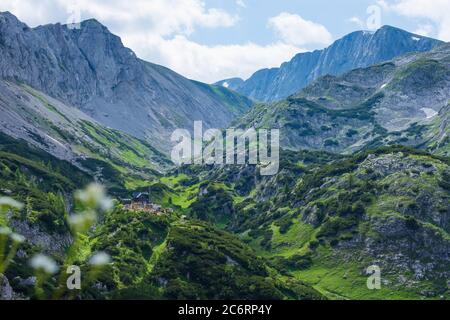 Montagne di Hochschwab: Vista al rifugio Voisthaler Hütte, e la cima Hochschwab (a destra) con croce sulla cima in Hochsteiermark, Steiermark, Stiria, Au Foto Stock