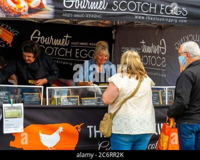 La gente che compra le uova di Scotch gourmet al mercato mensile degli agricoltori a Saltburn dal mare North Yorkshire Foto Stock