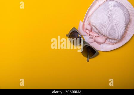 Su occhiali da sole gialli e cappello retrò a righe. Concetto estivo con spazio di copia per il tuo testo. Immagine con elevata rielaborazione. Foto Stock