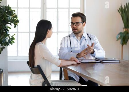 Medico serio che consulta la paziente femminile al meeting in clinica Foto Stock