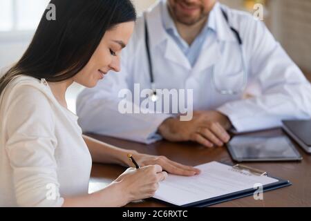 Primo piano paziente femminile modulo medico firma, contratto di assicurazione Foto Stock