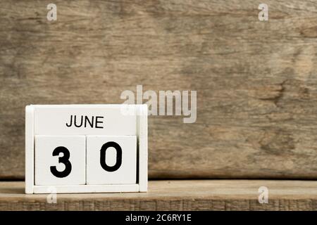 Calendario bianco blocco presente data 30 e mese giugno su sfondo legno Foto Stock