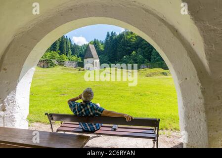 Uomini seduti in panchina e parlando al telefono all'interno della Zicka kartuzija (Zice certosa) Certosa Slovenia Foto Stock