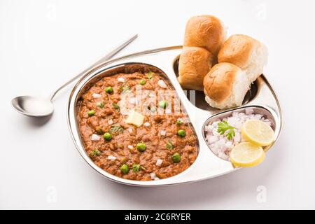 Il Bhaji Pad in stile Mumbai è un piatto fast food indiano, composto da un curry vegetale spesso servito con un morbido rotolo di pane, servito in un piatto Foto Stock