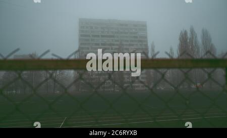 Gli sfondi della città urbana. Edificio a più piani al mattino, nella nebbia. Appartamento edificio dietro bar. Ghetto, che ospita i poveri. Concetto Foto Stock