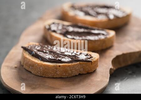 Ciabatta rustica con crema di cioccolato biologica su tavola di ulivo Foto Stock