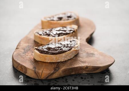 Ciabatta rustica con crema di cioccolato biologica su tavola di ulivo Foto Stock