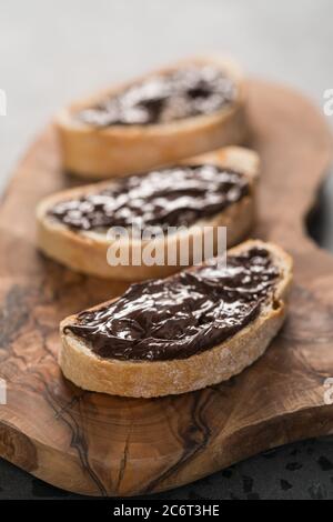 Ciabatta rustica con crema di cioccolato biologica su tavola di ulivo Foto Stock