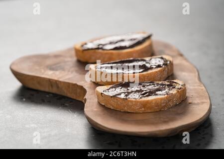 Ciabatta rustica con crema di cioccolato biologica su tavola di ulivo Foto Stock