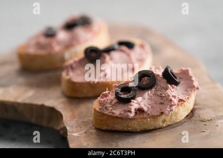 Ciabatta con pasta di carne su tavola di wowod d'oliva Foto Stock