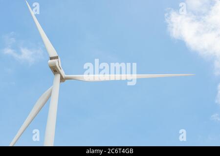 Turbina eolica a rotazione ravvicinata per generare energia elettrica all'aperto con sfondo blu, concetto di conservazione e energia sostenibile. Foto Stock