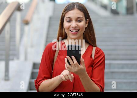 Ritratto di bella donna che scende le scale tenendo il telefono Foto Stock