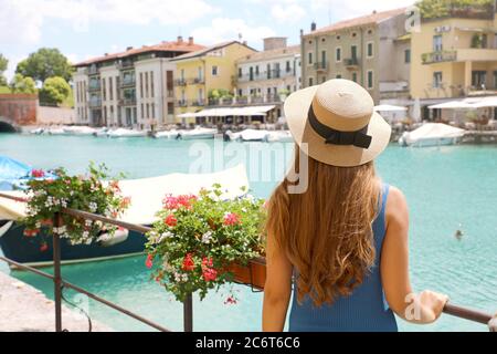 Vacanze in Europa. Indietro vista di bella ragazza di moda godendo di visitare il Lago di Garda. Vacanze estive in Italia. Foto Stock