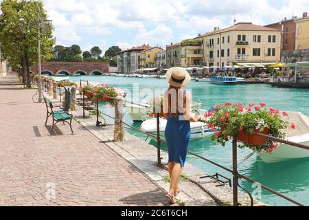 Viaggi in Italia. Indietro vista di bella ragazza di moda godendo di visitare il Lago di Garda. Vacanze estive in Italia. Foto Stock