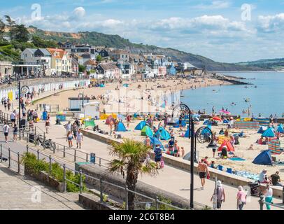 Lyme Regis, Dorset, Regno Unito. 12 luglio 2020. Regno Unito Meteo: Folle di beachgoers accorrono alla pittoresca località balneare di Lyme Regis per immergersi nel sole caldo e bruciante. Famiglie, visitatori e amanti del sole hanno fatto il pieno di spiaggia questo fine settimana per godersi il meglio del tempo soleggiato mentre i turisti fanno un wlecome ritorno alla popolare località. Credit: Celia McMahon/Alamy Live News Foto Stock