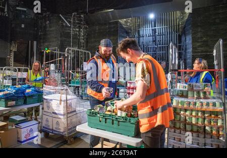 I membri del Consiglio delle Highlands impacchettano migliaia di pacchetti di cibo, con forniture per gli Highlanders che ancora schermano dalla pandemia del coronavirus, sul palco dell'Empire Theatre presso Eden Court a Inverness. Foto Stock