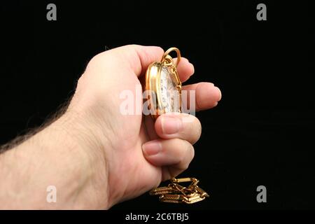 Sfondo nero di orologio da tasca dorato con catena. Foto Stock