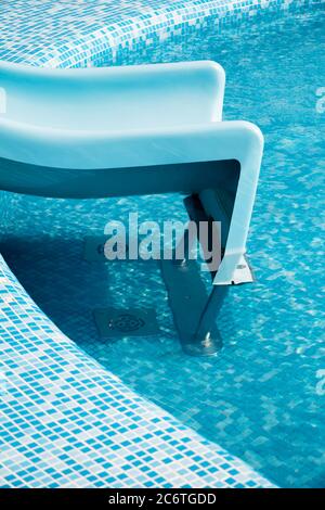 Piscina blu con scivolo d'acqua su un bellissimo e soleggiato pomeriggio estivo per sfondo, alta risoluzione Foto Stock