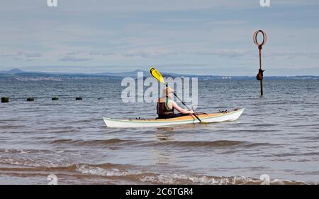 Portobello, Edimburgo, Scozia, UK 12 Luglio 2020. Temperatura 13 gradi al mattino che sale a 18 gradi al pomeriggio con poca brezza. Nella foto: Sport acquatici in kayak popolari negli ultimi tre mesi della pandemia di Coronavirus come persone di tutte le età hanno più sano inseguimenti nel loro tempo libero, così come i nuotatori selvatici regolari facendo un tuffo nel Firth of Forth. Foto Stock