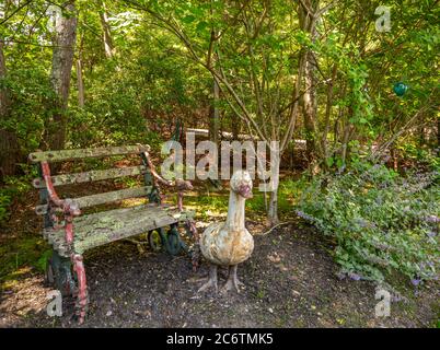 Antica scultura d'anatra e panca del parco con agenti atmosferici Foto Stock