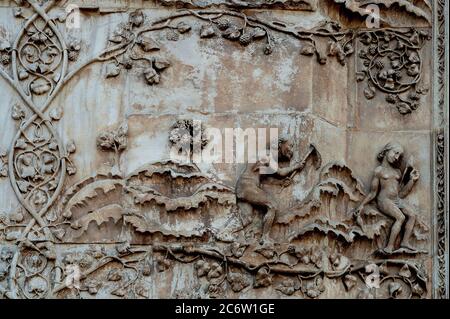 Adamo Delved ed Eva span: Dopo la loro espulsione dal Paradiso, Adamo cura il terreno mentre Eva siede filata, nel bassorilievo in marmo della Bibbia ebraica degli anni '1300 / Antico Testamento sul fronte occidentale della Cattedrale di Orvieto, Umbria, Italia. Questa scena scolpita è attribuita a Lorenzo Maitani (c. 1275 - 1330), che progettò la facciata tardo gotica della cattedrale. Si ritiene che Maitani abbia avuto un contributo diretto come scultore su due pannelli che coprono due dei quattro pilastri inferiori della facciata: Un pannello raffigura scene della Bibbia ebraica / Antico Testamento, inclusa la scena in questa immagine. Foto Stock