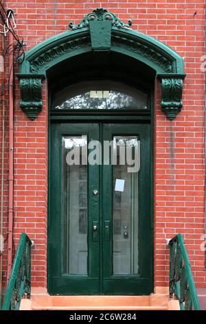 Verde vintage shabby-looking doppia porta d'ingresso decorata con arco segmentale, corbel e Keystone. New York. STATI UNITI. Foto Stock