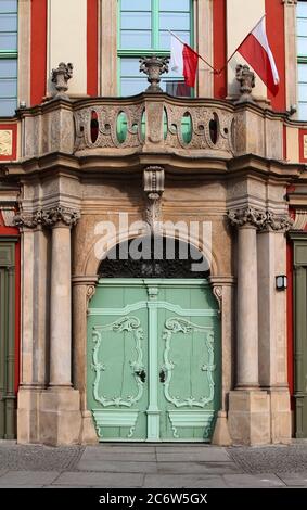 Porta d'ingresso doppia in legno verde chiaro decorata con sculture decorative, colonne, vasi e forgiatura. Piazza del mercato (Rynek). Wroclaw. Polonia. Foto Stock