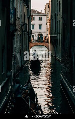 Una gondola si fa strada lungo un canale veneziano, Venezia, Veneto, Italia Foto Stock