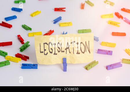 Legislazione sulla scrittura a mano. Foto concettuale una legge proposta da un governo e resa legale da un parlamento carte colorate per stendere i vestiti vuote r Foto Stock