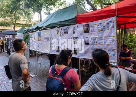 Hong Kong, Cina. 12 luglio 2020. Si vedono persone che leggono informazioni in una stazione di scrutinio temporaneo durante le elezioni primarie non ufficiali. Credit: SOPA Images Limited/Alamy Live News Foto Stock