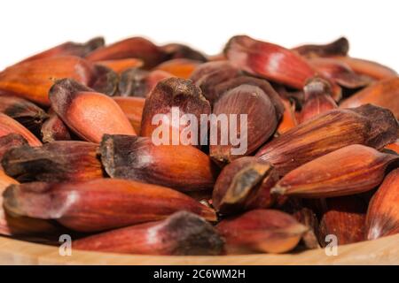 Porzione di frutta a pignone brasiliana cruda su una ciotola di bambù con fondo bianco Foto Stock