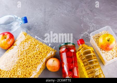 Donazioni di cibo su sfondo grigio. Forniture alimentari. Vista dall'alto. Spazio di copia Foto Stock